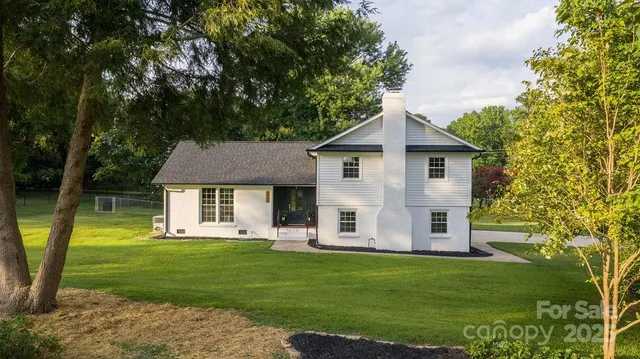 a front view of a house with a garden and trees