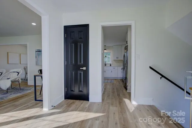a view of a hallway with wooden floor windows and a livingroom