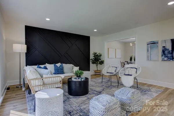 a living room with furniture a rug and a potted plant