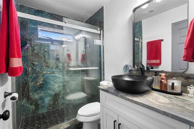 a bathroom with a sink a toilet and shower