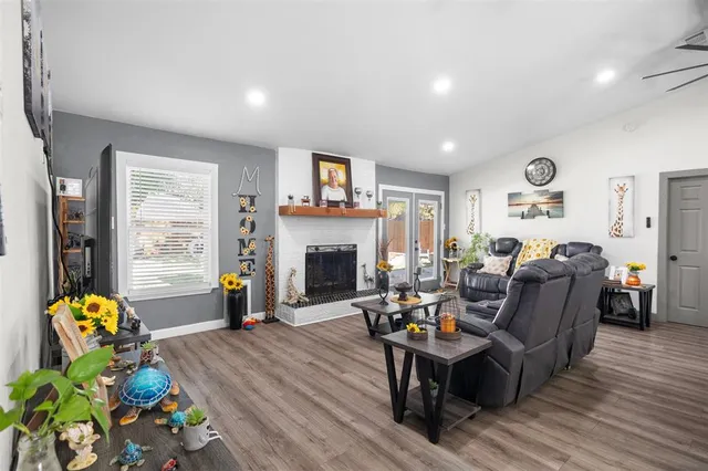 a kitchen with stainless steel appliances granite countertop a refrigerator a stove top oven a sink dishwasher and white cabinets with wooden floor