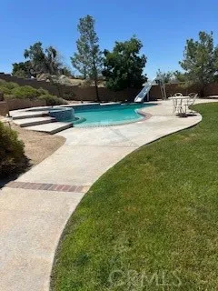 a view of yard with swimming pool and trees in the background