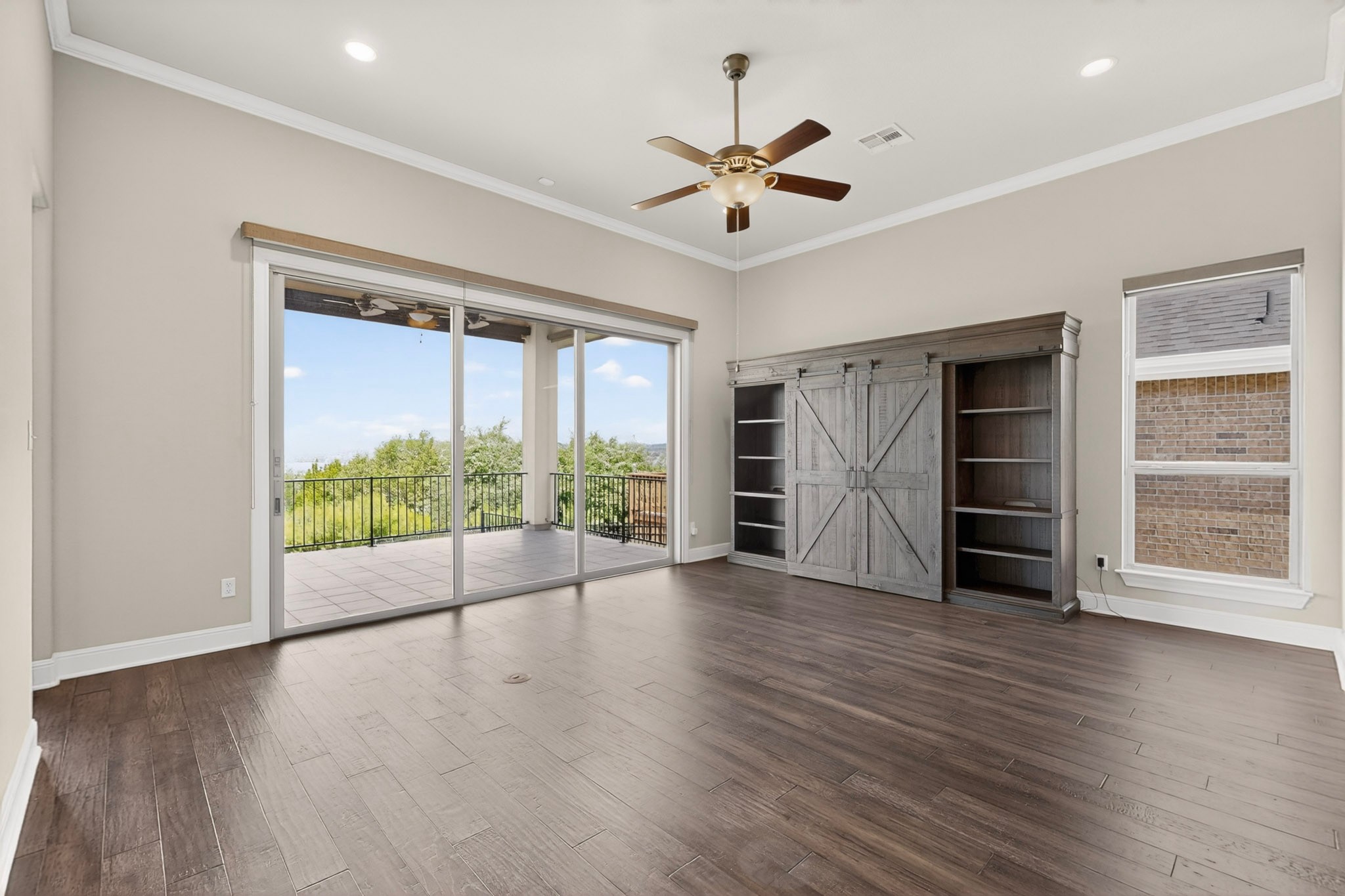 2617 Milan Meadows Drive Leander, TX 78641 - Photo 3 of 40 Hardwood floors and a wide glass door leading to a balcony define this inviting room.
