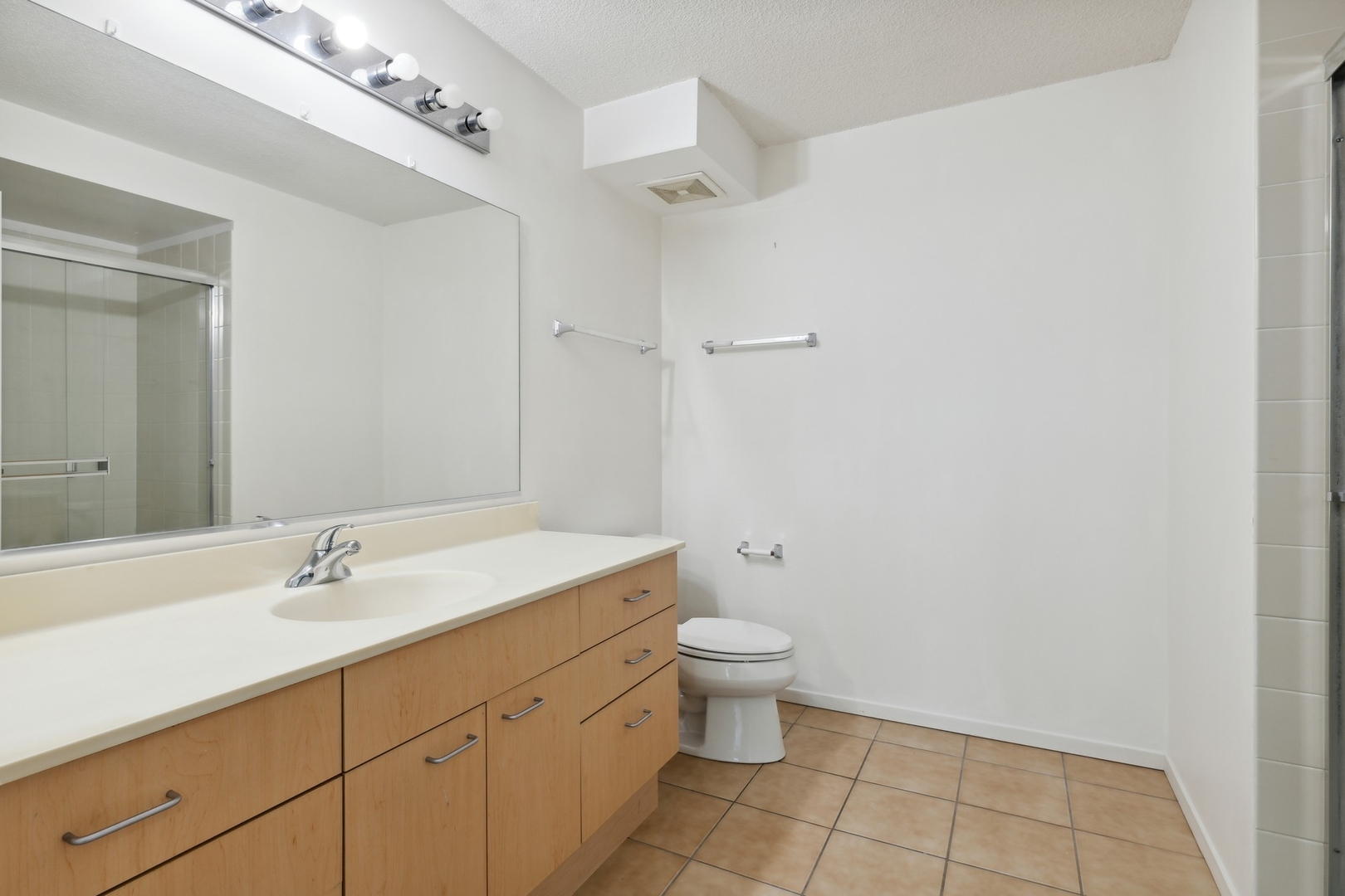 800 Elgin Road, Unit 1109 Evanston, IL 60201 - Photo 8 of 17 a bathroom with a sink a toilet and a mirror