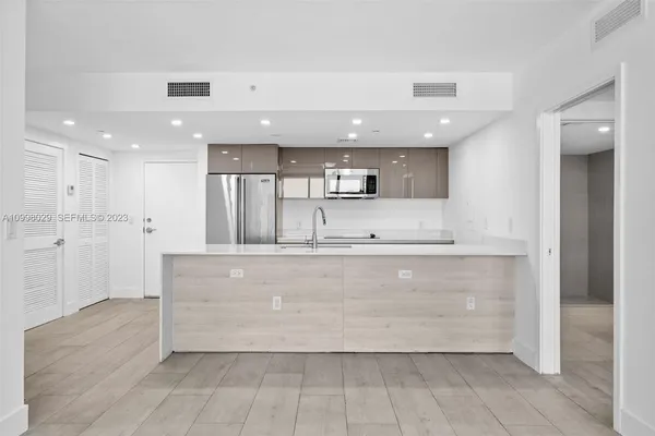 a kitchen with stainless steel appliances granite countertop a sink and a refrigerator