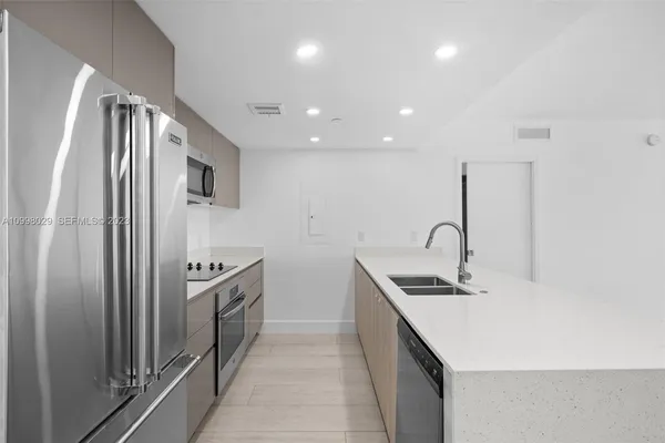 a kitchen with stainless steel appliances a refrigerator sink and stove