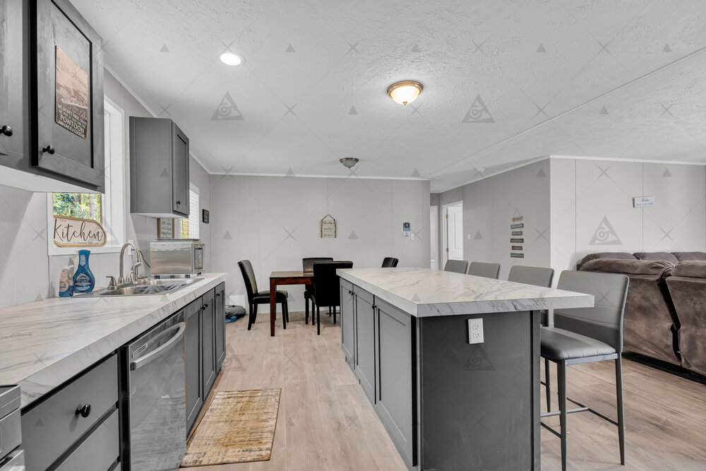 A spacious kitchen features a long center island and durable wood-look flooring.