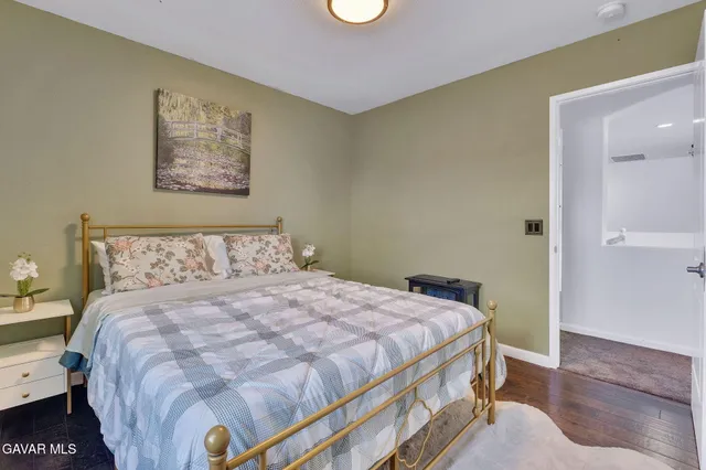 a bedroom with a bed and painting on the wall