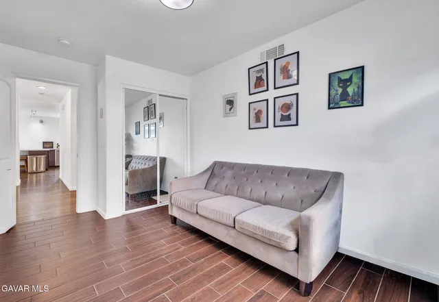 a living room with furniture and a wooden floor