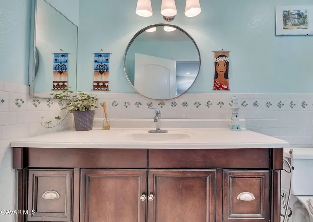 a bathroom with a sink vanity and a mirror
