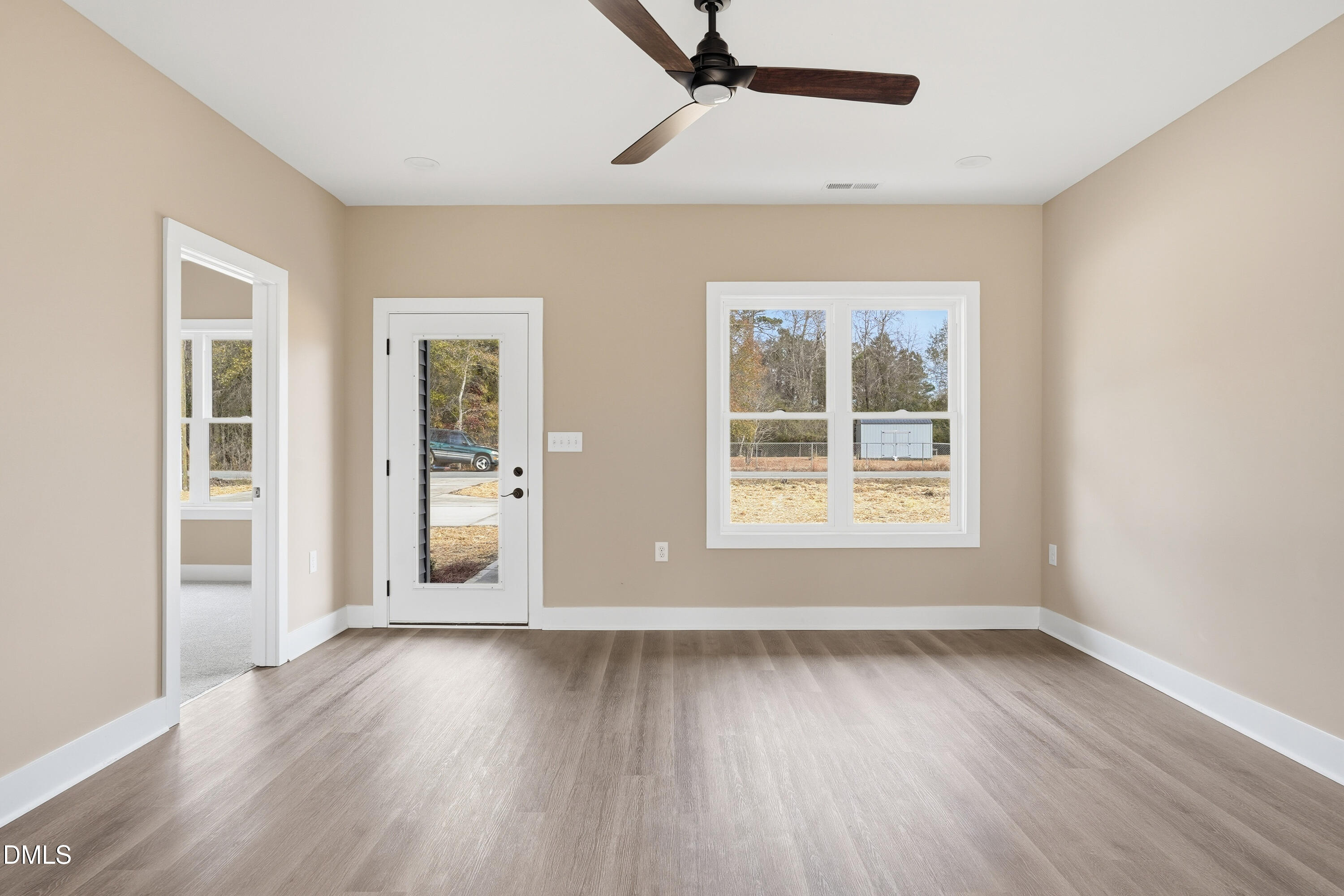 1115 Jada Allen Road Dunn, NC 28334 - Photo 6 of 32 a view of an empty room with wooden floor and a window