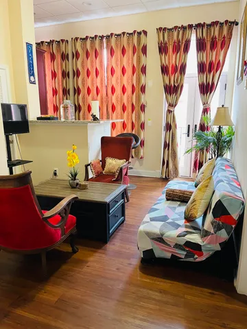 a living room with furniture and a wooden floor