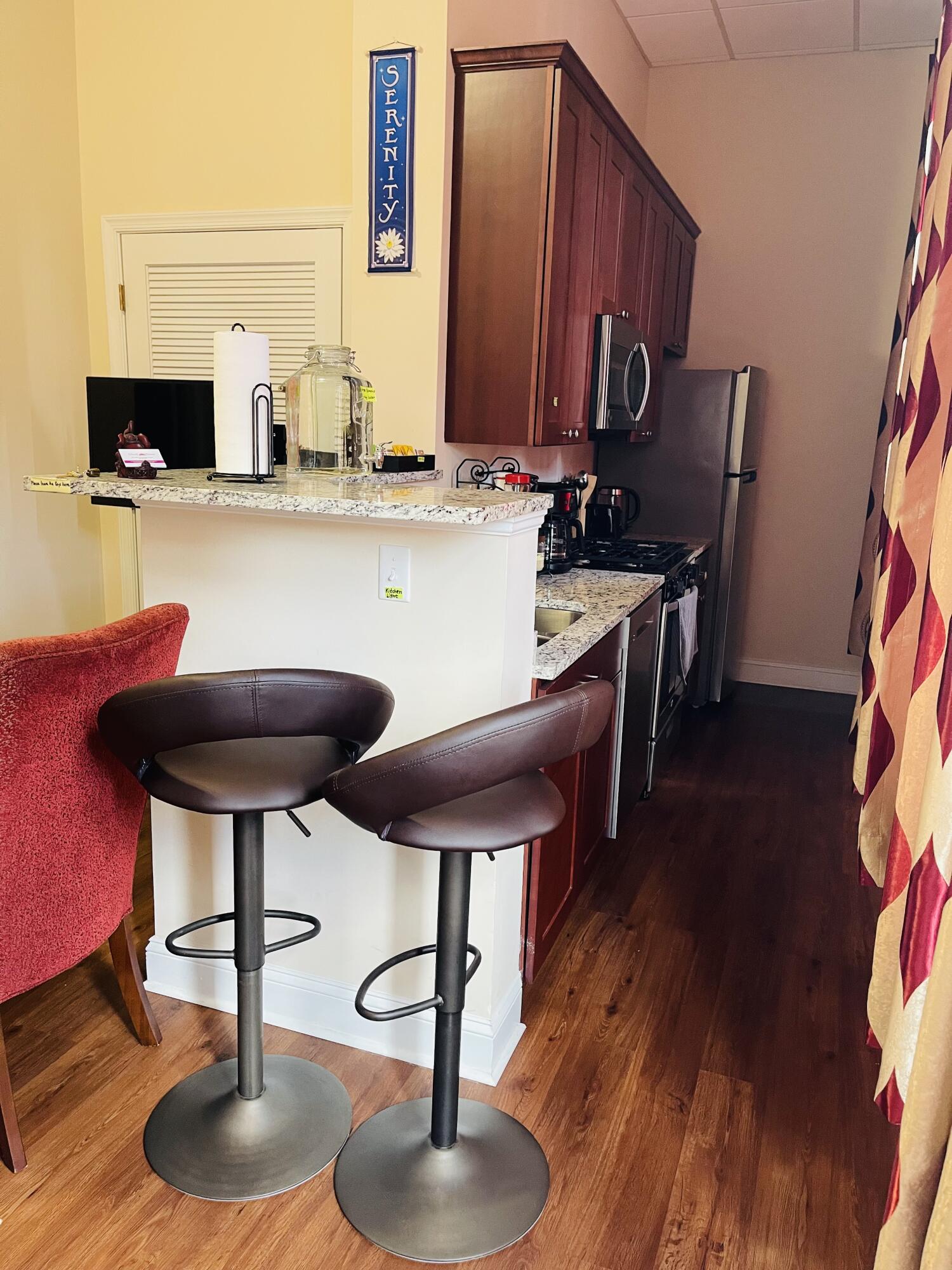 100 Kirk Avenue Southeast, Unit 2B Roanoke, VA 24011 - Photo 4 of 8 a kitchen with stainless steel appliances a dining table chairs and a wooden floor