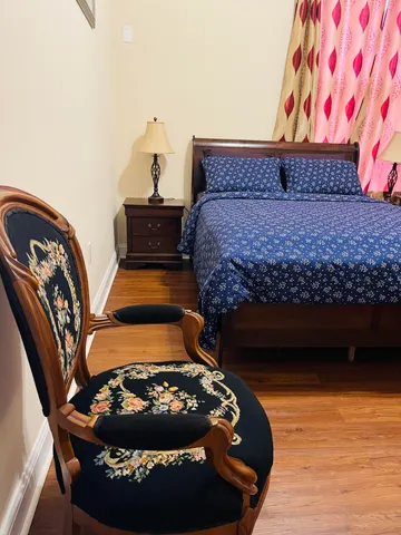 a bed sitting in a bedroom next to a lamp