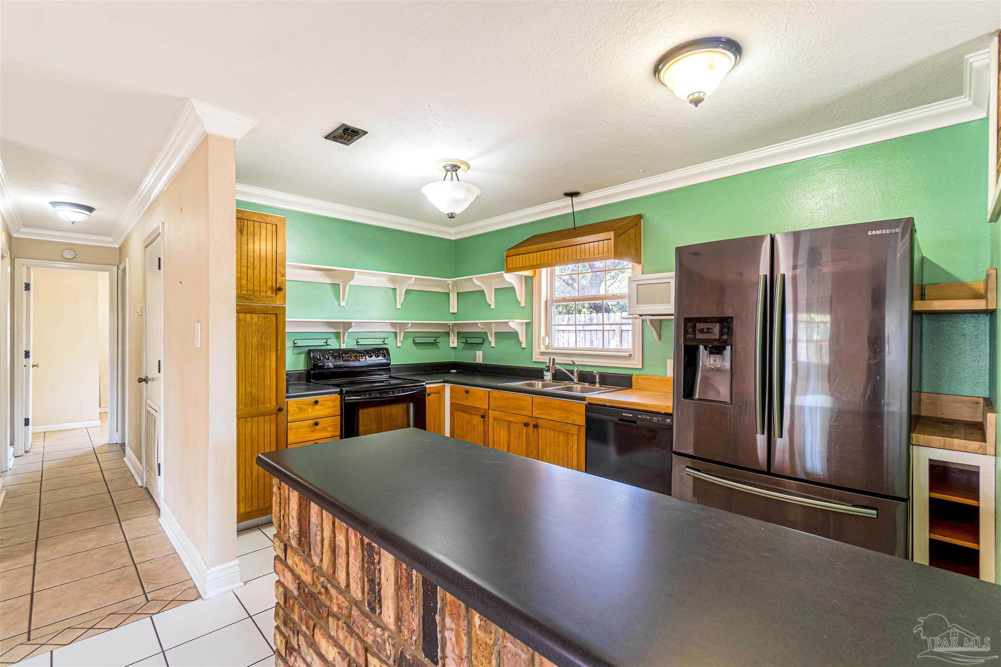 1961 Guseman Road Gulf Breeze, FL 32563 - Photo 6 of 37 a kitchen with stainless steel appliances granite countertop a refrigerator and a sink