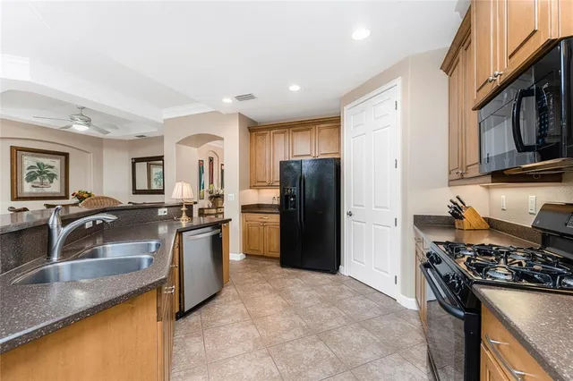 a kitchen with stainless steel appliances granite countertop a sink dishwasher stove top oven and cabinets with wooden floor