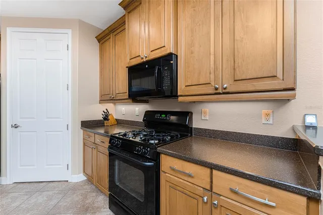 a kitchen with stainless steel appliances granite countertop a refrigerator a stove top oven a sink dishwasher and white cabinets with wooden floor