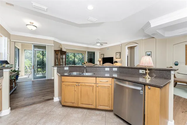 a living room with furniture kitchen view and a chandelier