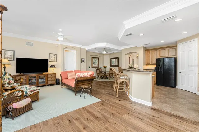 a spacious bedroom with a bed a chandelier and a large window