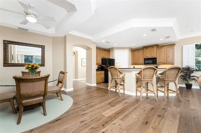 a kitchen with stainless steel appliances a dining table chairs stove refrigerator and cabinets