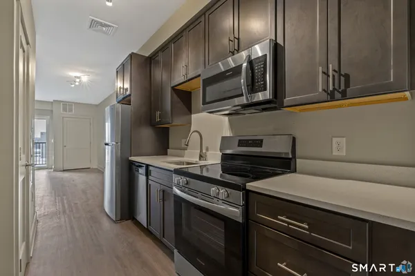 a kitchen with stainless steel appliances a stove microwave and cabinets
