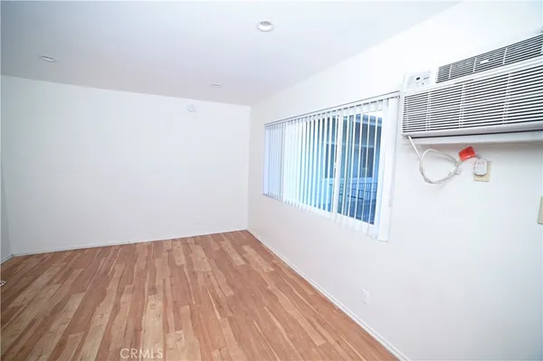 a view of a hallway with wooden floor and a window