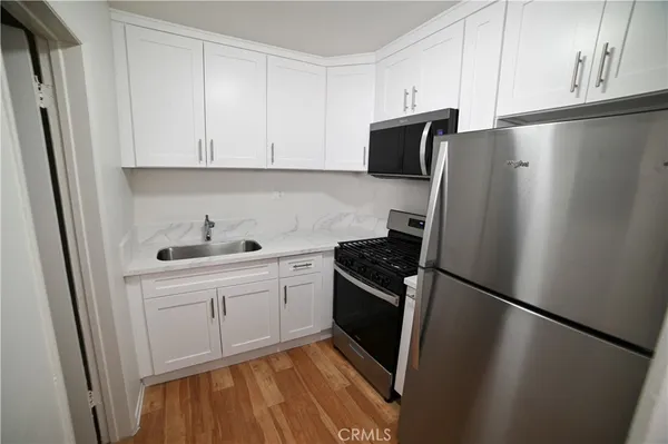 a kitchen with stainless steel appliances a refrigerator a sink and cabinets