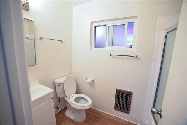 a white toilet sitting next to a bathroom sink and vanity