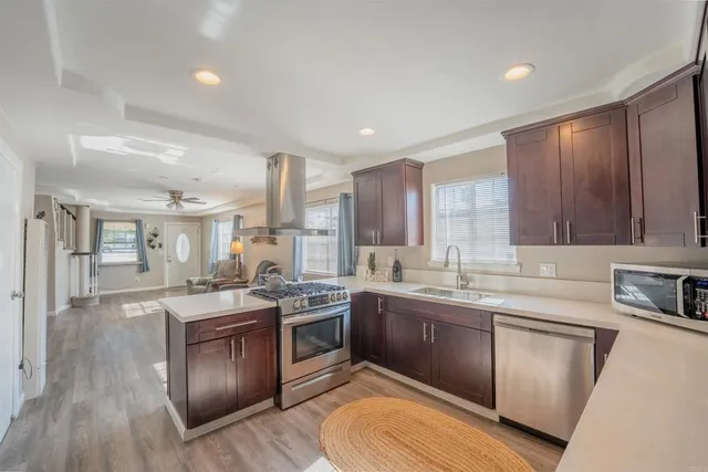 a kitchen with stainless steel appliances granite countertop wooden cabinets sink and stove