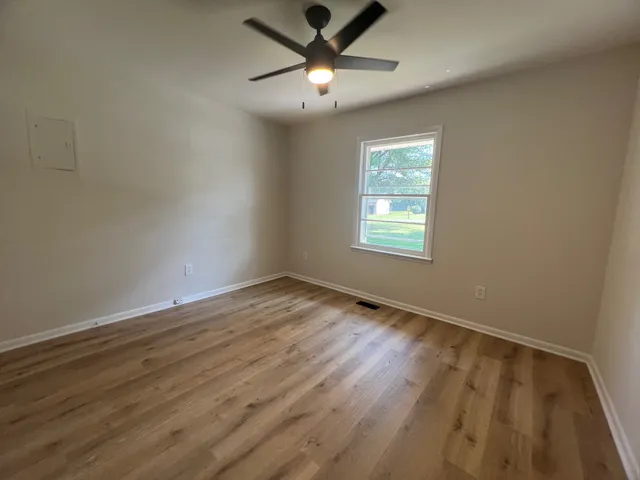 a view of an empty room and window and wooden floor