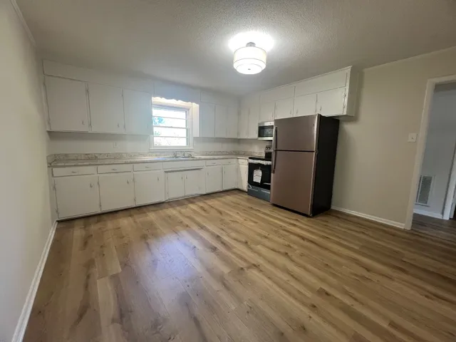 a kitchen with a refrigerator and a stove top oven