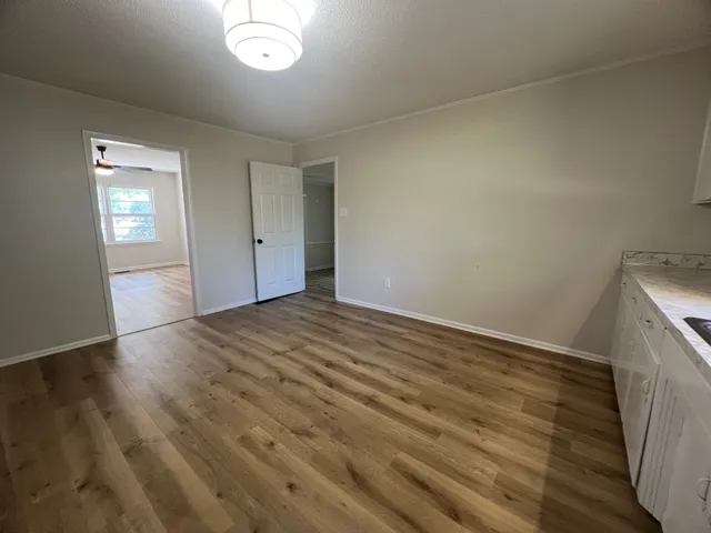 a view of empty room with wooden floor
