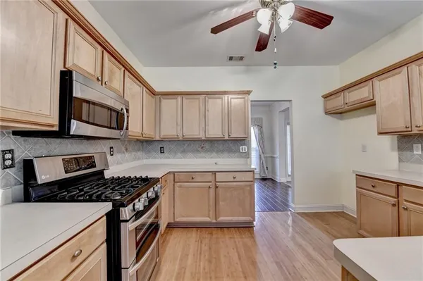 a kitchen with stainless steel appliances granite countertop wooden cabinets a stove a sink and dishwasher