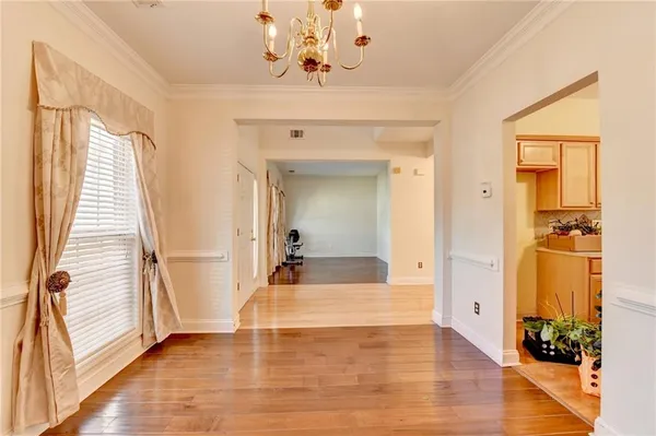 a view of a hallway with wooden floor and a living room