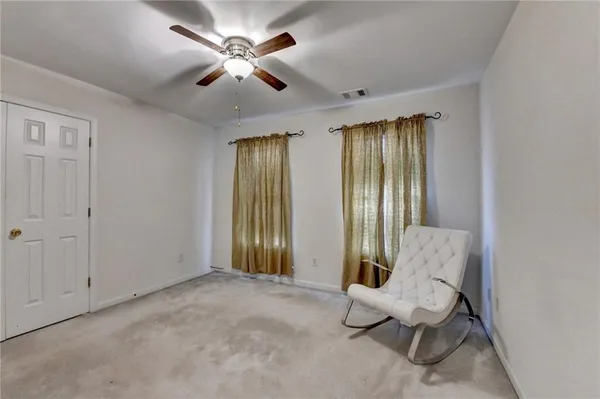 a living room with furniture and a ceiling fan