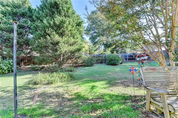 a view of backyard with table and chairs and large trees