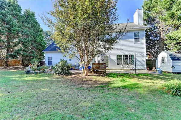a view of a house with backyard and a tree
