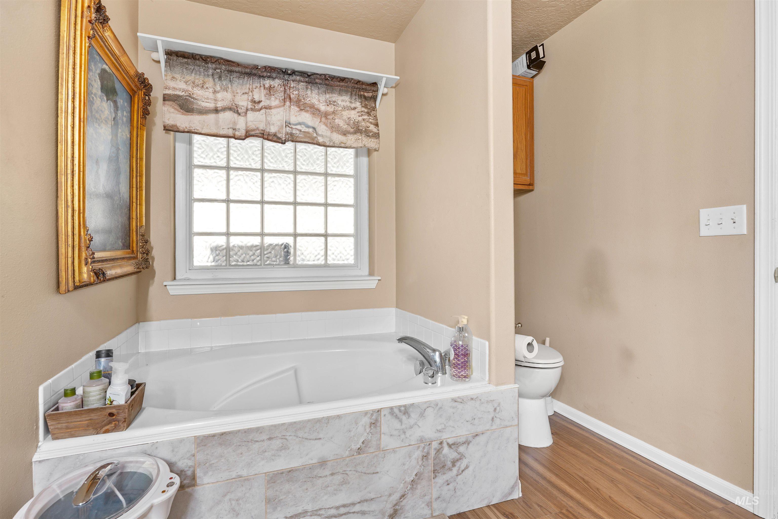 500 East 19th Street Burley, ID 83318 - Photo 11 of 31 Full bath featuring a bath, wood finished floors, and a textured ceiling