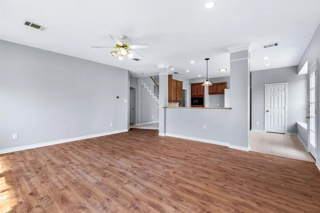 a view of a kitchen with a kitchen island wooden floor and ceiling fan