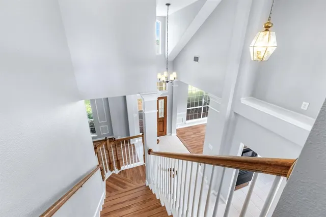 a view of a hallway with wooden floor and stairs