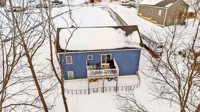 an aerial view of a house with yard and covered in snow