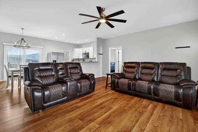 a living room with furniture a ceiling fan and a rug