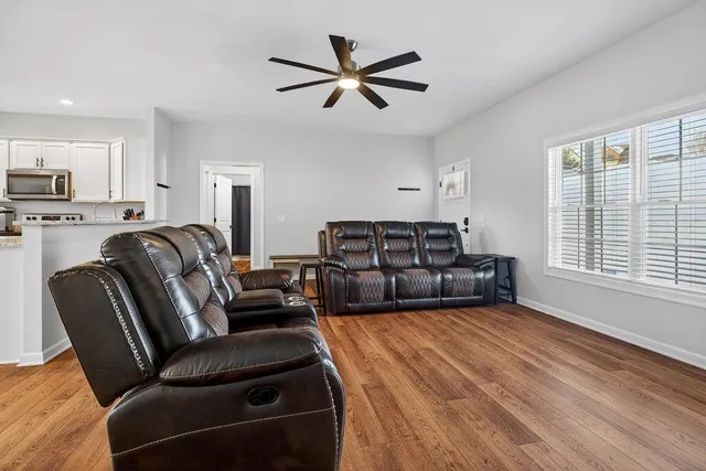 a living room with furniture a ceiling fan and a window
