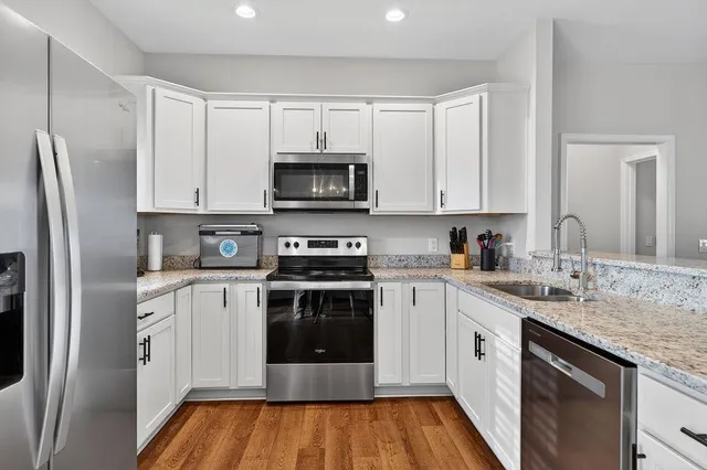 a kitchen with stainless steel appliances granite countertop a stove a sink and a refrigerator