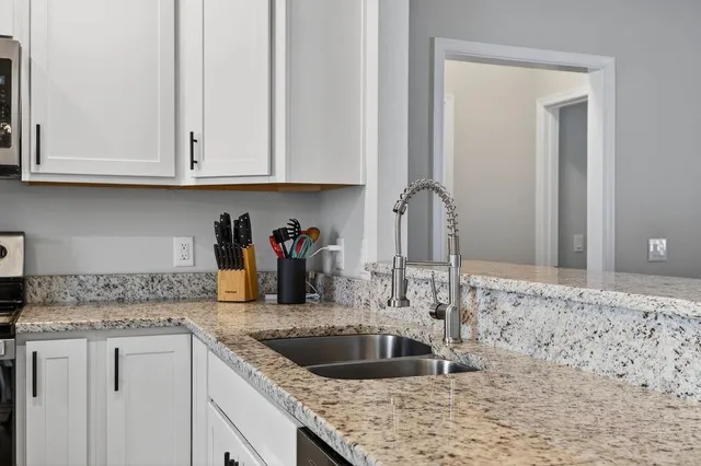 a kitchen with granite countertop a sink and cabinets