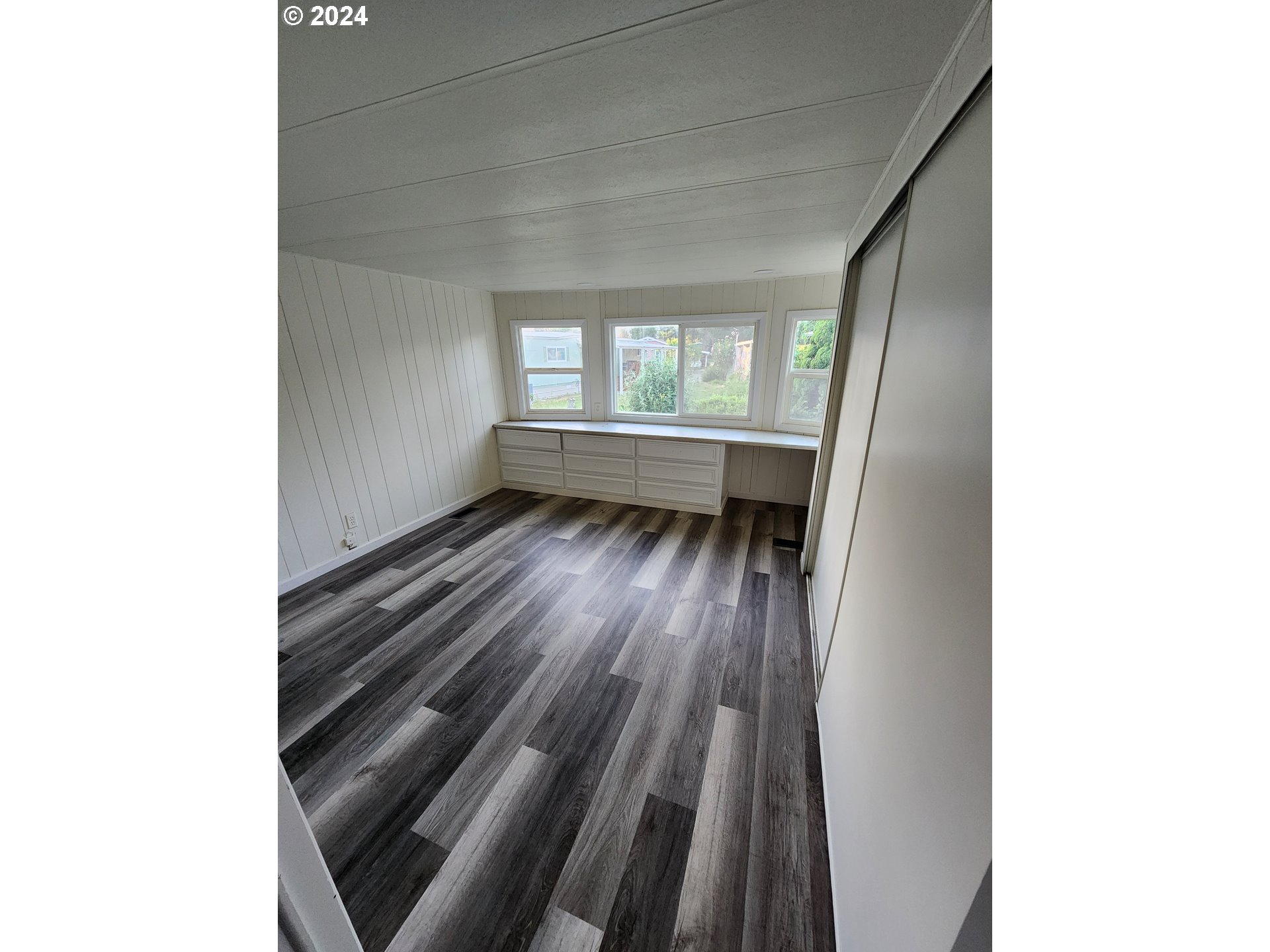 1125 58th Street, Unit 35 Springfield, OR 97478 - Photo 12 of 15 a view of an empty room with wooden floor and a window