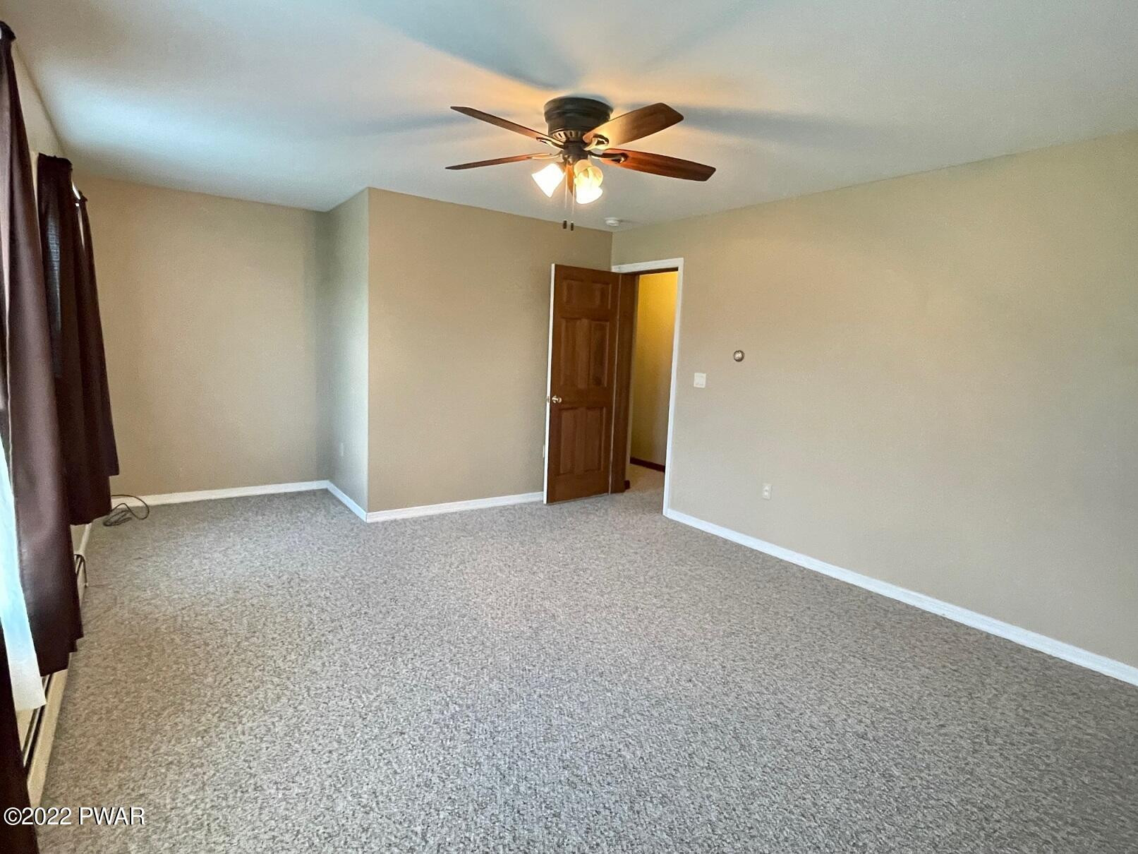 524 Creamton Drive Prompton, PA 18456 - Photo 39 of 57 an empty room with a ceiling fan and a window