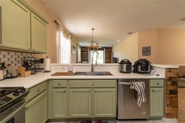 a kitchen with kitchen island granite countertop a sink a stove and cabinets