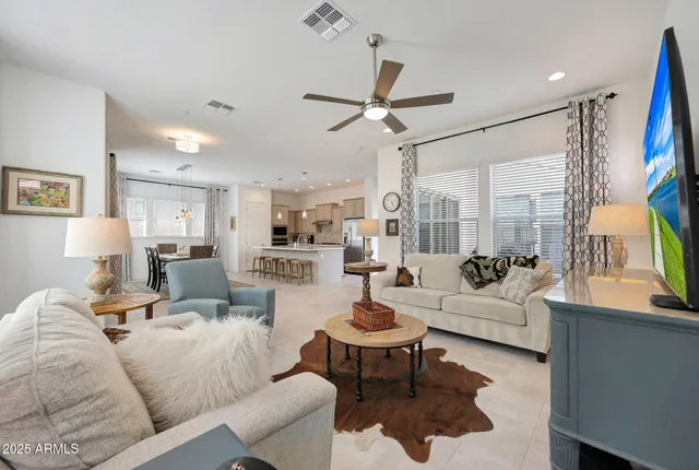 a living room with furniture fireplace and a large window