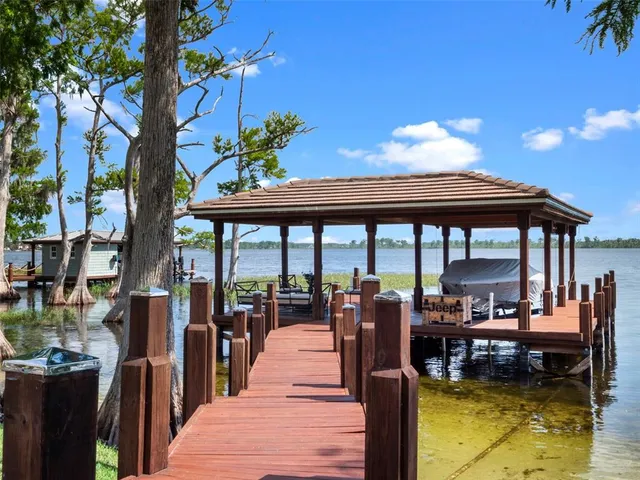 a view of swimming pool with seating area and trees in the background